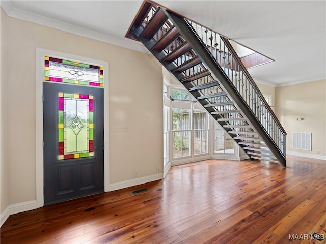 foyer featuring crown molding and dark wood-type flooring