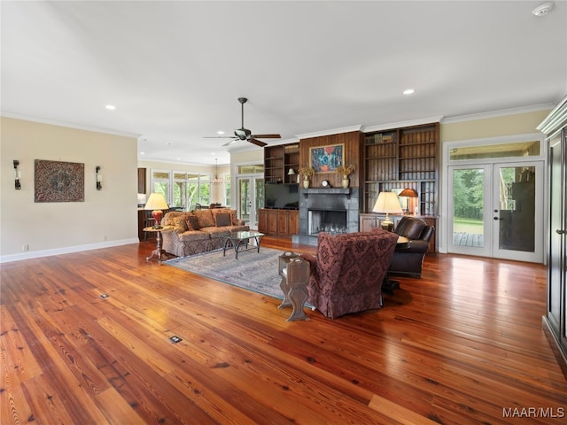 living room featuring plenty of natural light, ceiling fan, hardwood / wood-style flooring, and crown molding