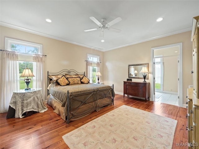 bedroom with multiple windows, wood-type flooring, ornamental molding, and ceiling fan