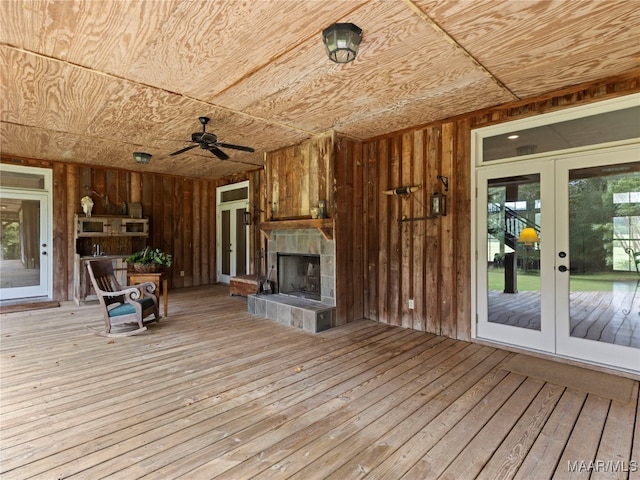 interior space featuring ceiling fan, french doors, and a tile fireplace