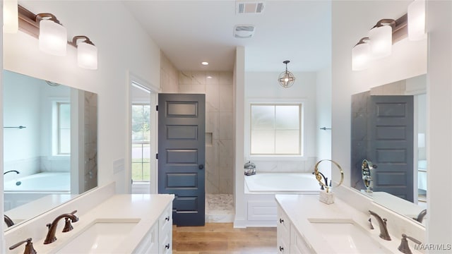 bathroom with independent shower and bath, hardwood / wood-style flooring, vanity, and a wealth of natural light