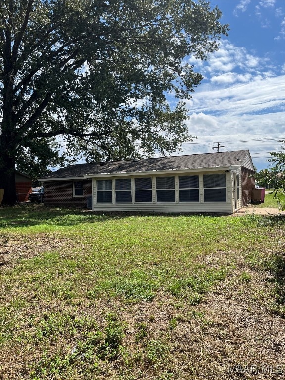 rear view of property featuring a yard