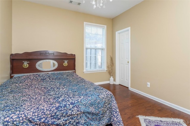 bedroom with an inviting chandelier and hardwood / wood-style flooring