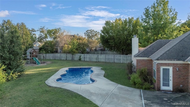 view of swimming pool with a lawn and a playground