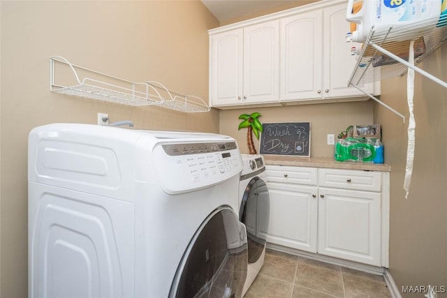 washroom featuring cabinets, washer and clothes dryer, and light tile patterned floors