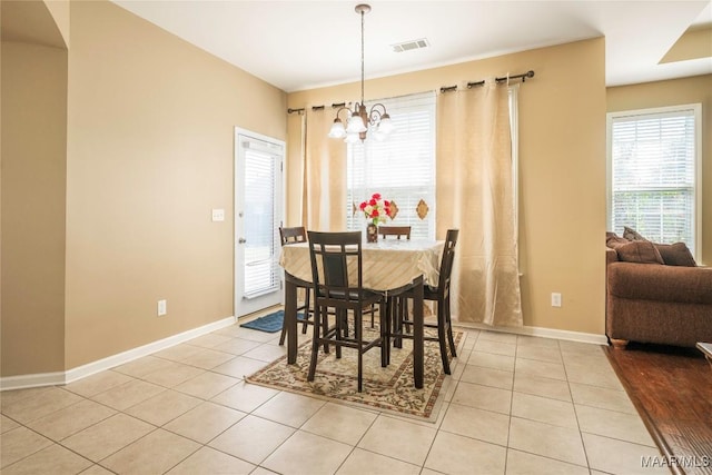 dining room featuring light tile patterned flooring and a chandelier