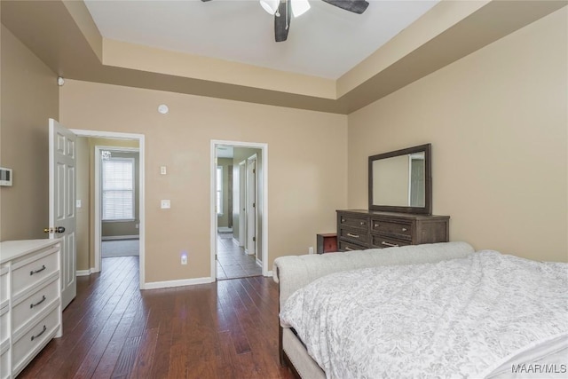 bedroom with a raised ceiling and dark wood-type flooring