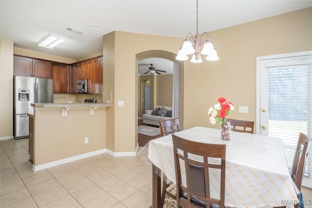 kitchen with appliances with stainless steel finishes, pendant lighting, tasteful backsplash, light tile patterned floors, and kitchen peninsula