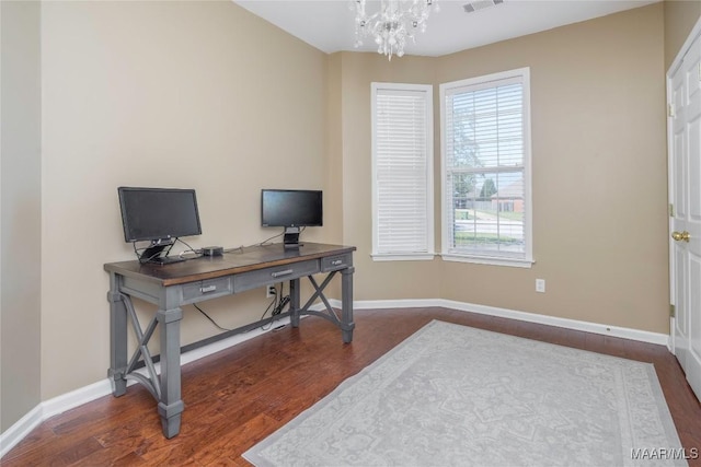 home office featuring dark wood-type flooring and a notable chandelier