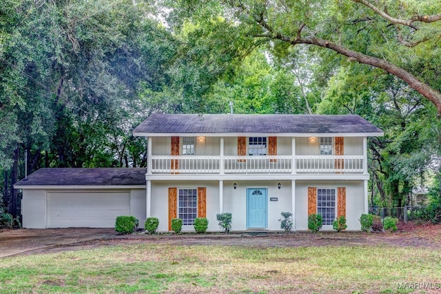 view of front of home featuring a balcony, a garage, and a front lawn