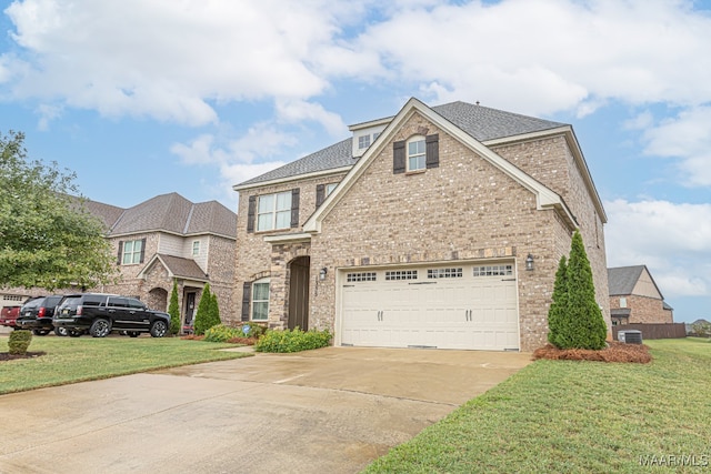 view of front of home with a front yard, cooling unit, and a garage