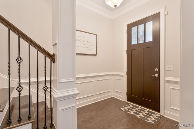 foyer entrance with ornamental molding and dark hardwood / wood-style flooring