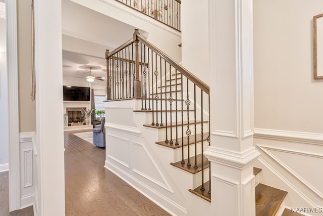 stairway with ceiling fan and hardwood / wood-style flooring