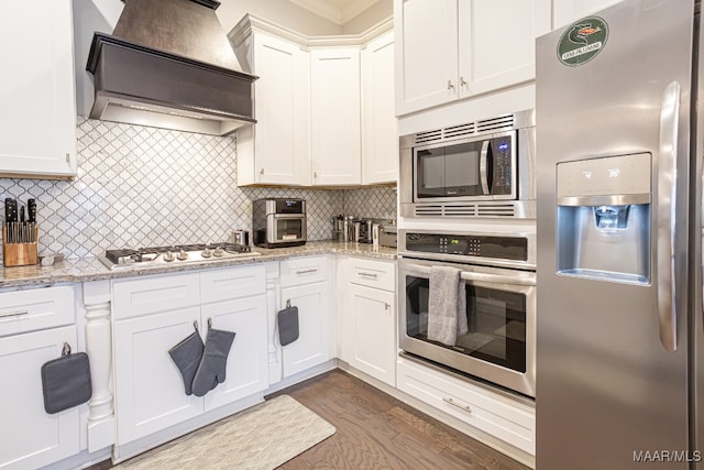 kitchen featuring custom exhaust hood, white cabinetry, stainless steel appliances, dark hardwood / wood-style flooring, and decorative backsplash