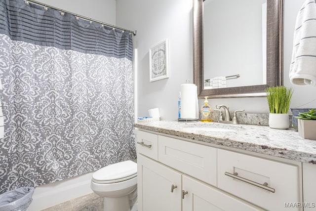 bathroom with tile patterned floors, walk in shower, vanity, and toilet