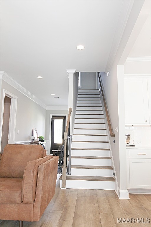 stairway with crown molding and hardwood / wood-style flooring