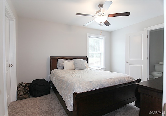 bedroom featuring carpet, ceiling fan, and ensuite bath