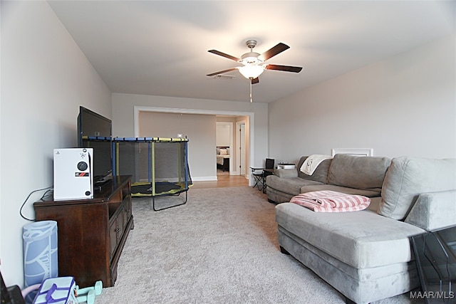 living room featuring light wood-type flooring and ceiling fan