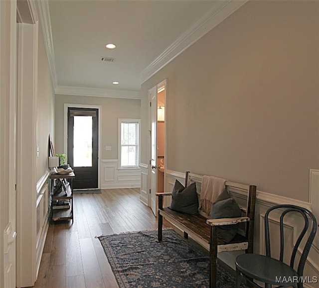 entryway with hardwood / wood-style flooring and crown molding