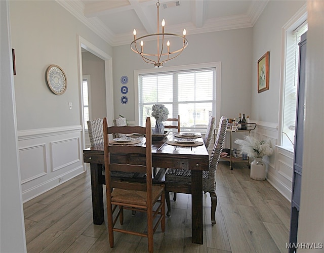 dining space with an inviting chandelier, coffered ceiling, hardwood / wood-style flooring, and crown molding