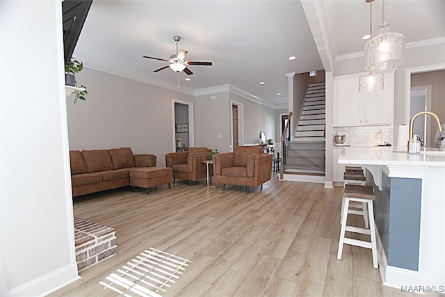 living room with ceiling fan, sink, crown molding, and light hardwood / wood-style floors