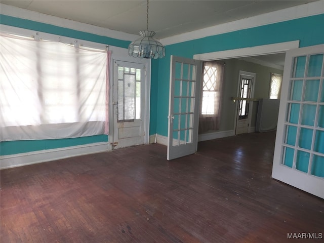 spare room with ornamental molding, a chandelier, and dark hardwood / wood-style flooring