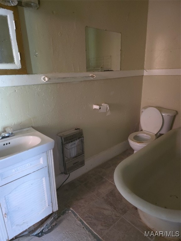 bathroom featuring heating unit, tile patterned floors, vanity, and toilet