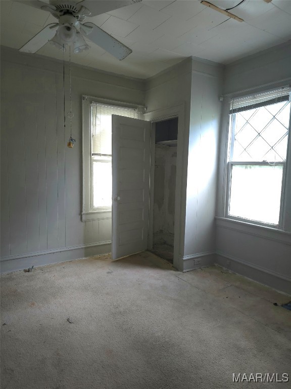 unfurnished bedroom featuring light carpet, ceiling fan, and a closet