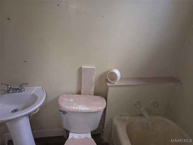 bathroom featuring sink, a washtub, and toilet