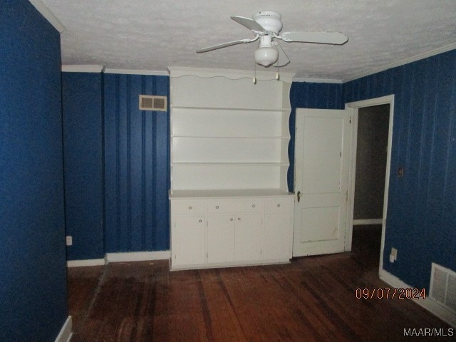 spare room with a textured ceiling, ceiling fan, dark hardwood / wood-style floors, and crown molding