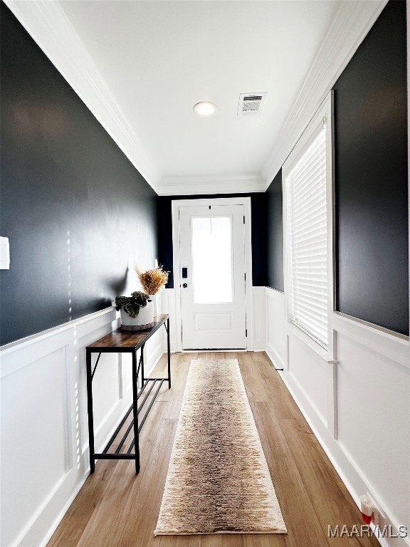 foyer entrance featuring crown molding and light hardwood / wood-style floors