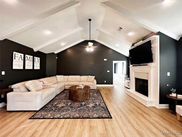 living room with a fireplace, light hardwood / wood-style flooring, vaulted ceiling with beams, ornamental molding, and ceiling fan