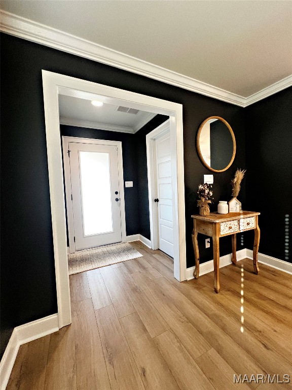 foyer with light hardwood / wood-style flooring and crown molding