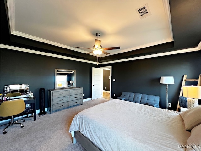 carpeted bedroom with ornamental molding, a tray ceiling, and ceiling fan