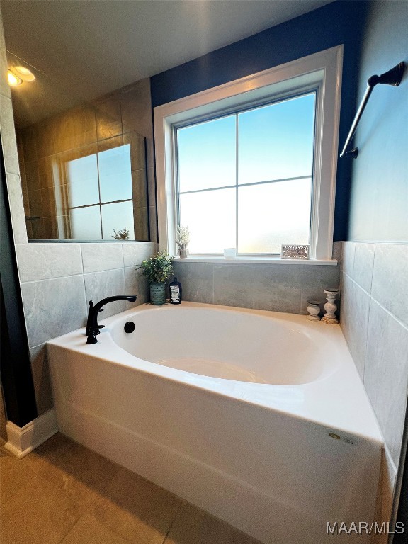 bathroom with a bath and tile patterned floors