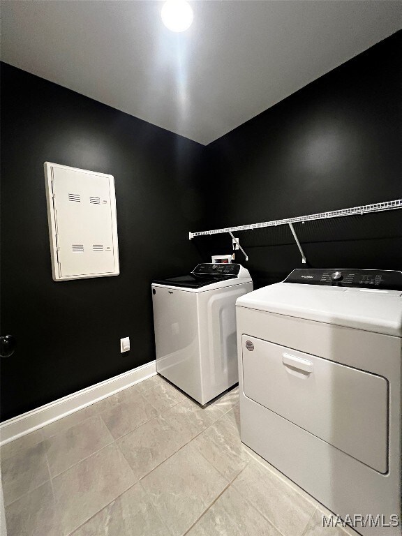 washroom featuring light tile patterned floors and washer and clothes dryer