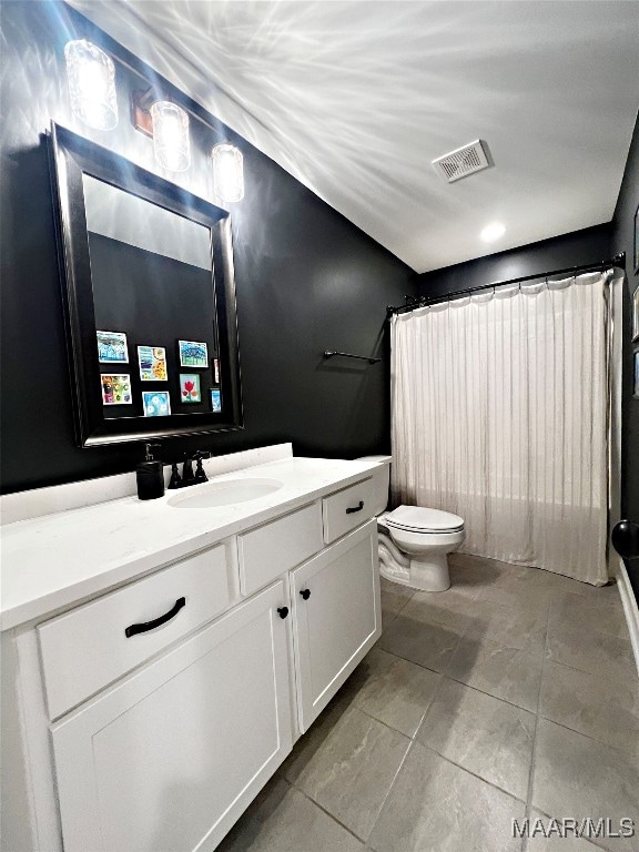 bathroom with vanity, tile patterned flooring, toilet, and curtained shower