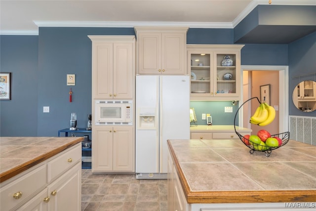 kitchen with white appliances, tile countertops, and ornamental molding