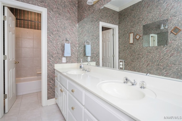 bathroom with tile patterned flooring, vanity, ornamental molding, and tiled shower / bath combo