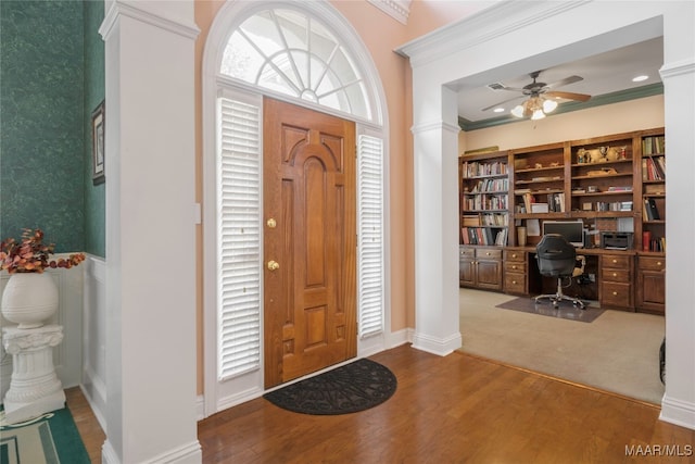 entryway with ornate columns, ceiling fan, ornamental molding, and hardwood / wood-style flooring