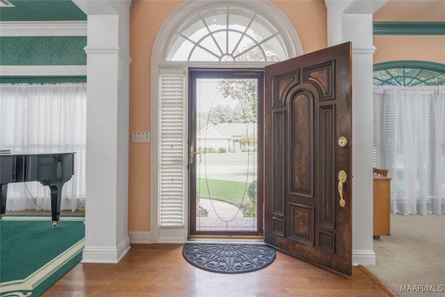 foyer entrance with hardwood / wood-style floors and ornamental molding