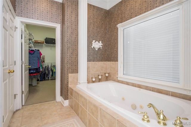 bathroom with tile patterned floors, crown molding, and a relaxing tiled tub