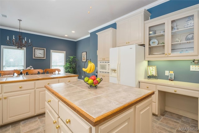 kitchen with tile countertops, white appliances, ornamental molding, decorative light fixtures, and a kitchen island