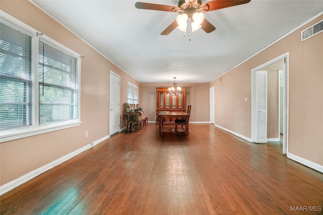 unfurnished living room featuring ceiling fan with notable chandelier and dark hardwood / wood-style floors