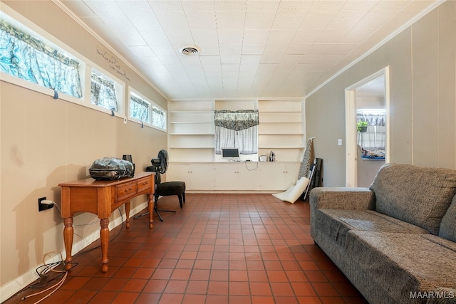 living room with ornamental molding, built in features, and dark tile patterned floors