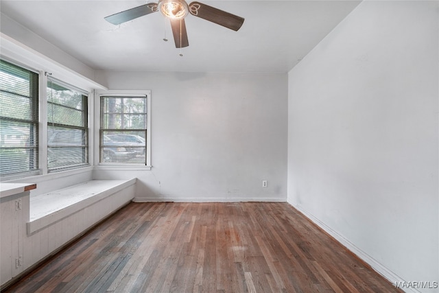 empty room with ceiling fan and dark wood-type flooring