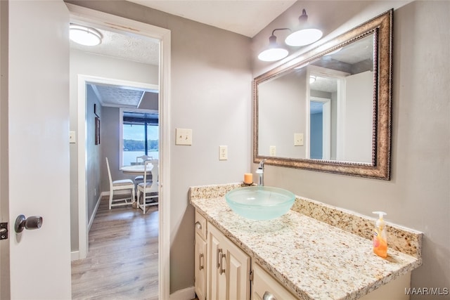 bathroom featuring vanity, hardwood / wood-style floors, and a textured ceiling