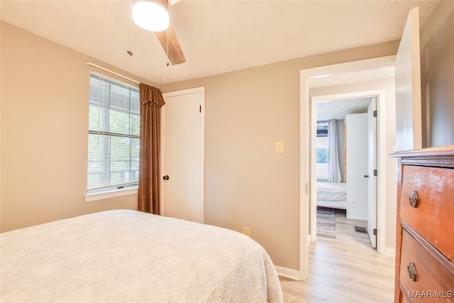 bedroom with ceiling fan, a textured ceiling, and light hardwood / wood-style flooring