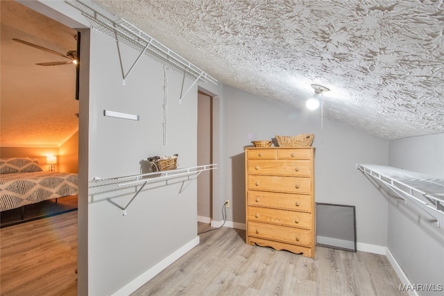 walk in closet with hardwood / wood-style floors and ceiling fan