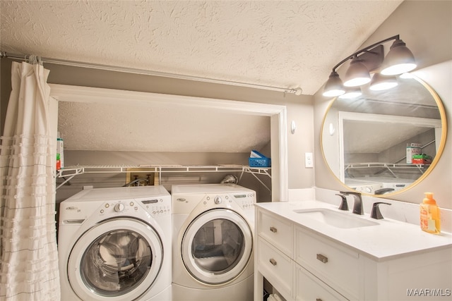 laundry area featuring a textured ceiling, separate washer and dryer, and sink